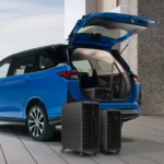 Blue Toyota Veloz SUV with open tailgate displaying cargo space and travel luggage on concrete surface