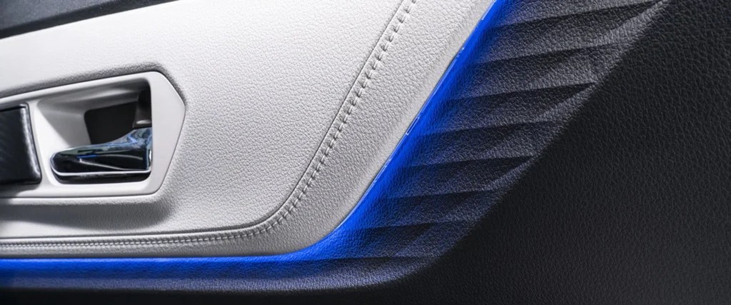 Toyota Veloz interior door panel detail with gray leather and blue accent trim plus chrome door handle
