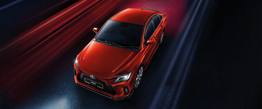 Toyota Vios red car overhead perspective showing roof design with dramatic lighting and speed effects