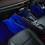 Car interior detail featuring Toyota Vios gear selector and console with atmospheric lighting effects