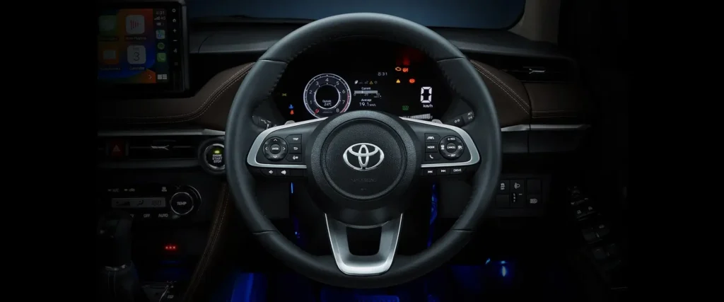 Car dashboard showing Toyota Vios steering wheel controls and modern gauge cluster with digital readouts