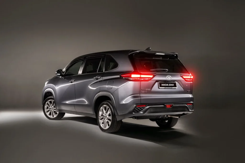 Rear three-quarter view of Toyota Innova Zenix with illuminated LED taillights and modern styling
