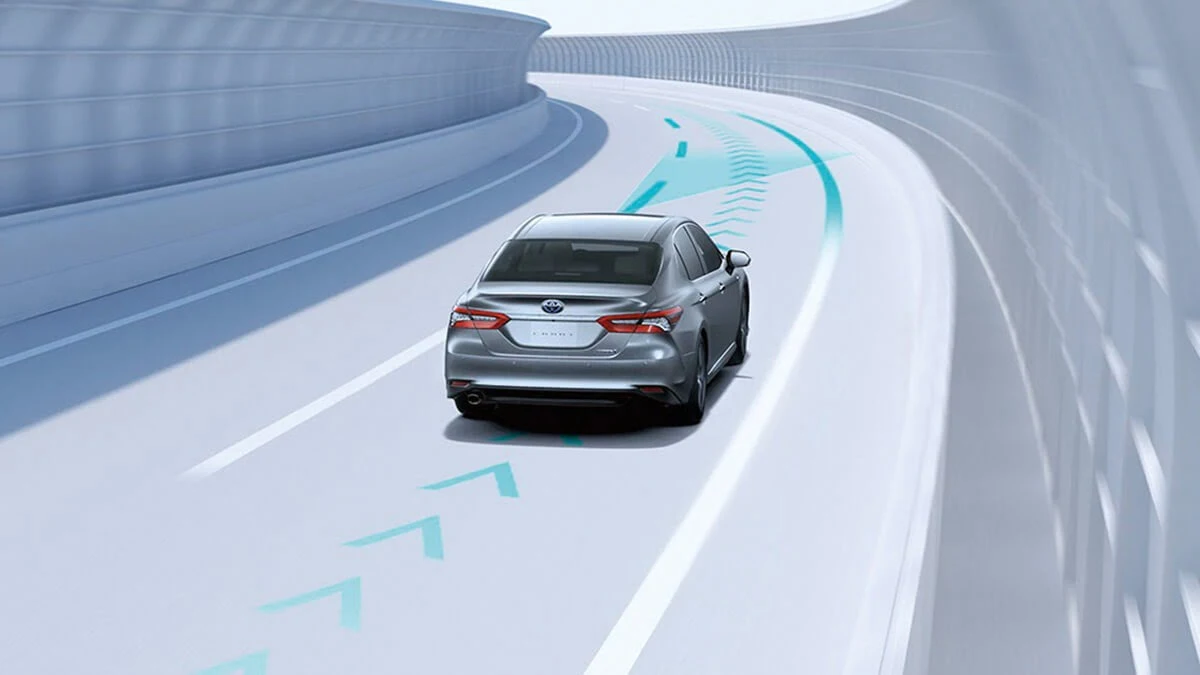Toyota Camry demonstarting Safety Sense Lane Tracing Assist (LTA) on winding road with directional safety indicators