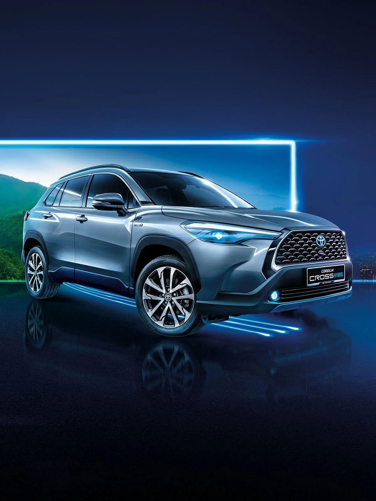 Silver Toyota Corolla Cross Hybrid Electric in futuristic studio with blue neon lighting and mountain landscape backdrop