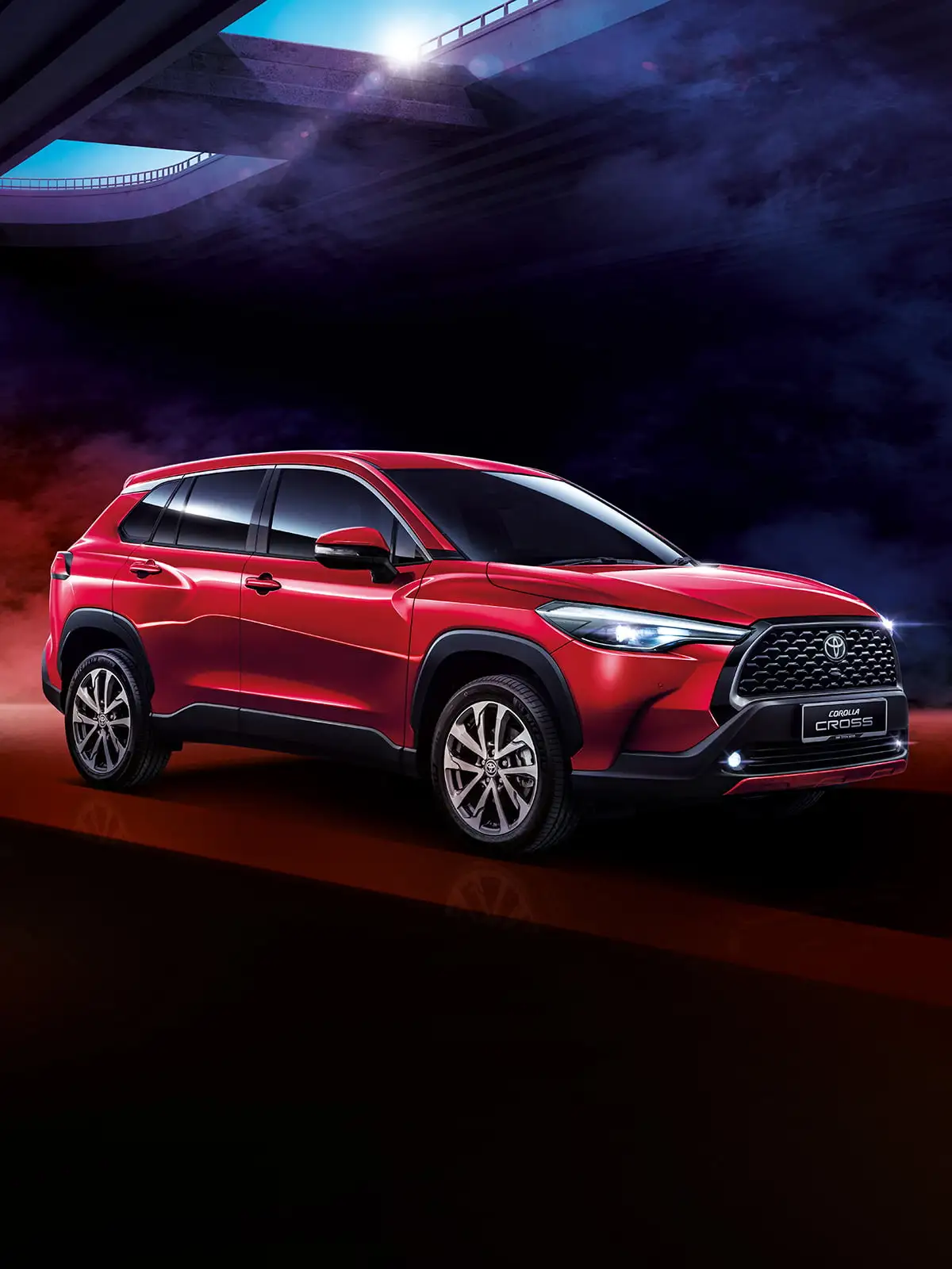 Red Toyota Corolla Cross positioned on dramatic dark surface with colorful smoke and futuristic lighting effects