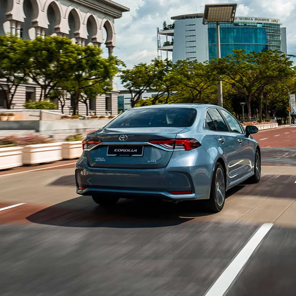Back view of Toyota Corolla on the road with city view