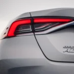 Close-up detail of Toyota Corolla rear taillight with LED technology and Corolla Altis badge on white paint