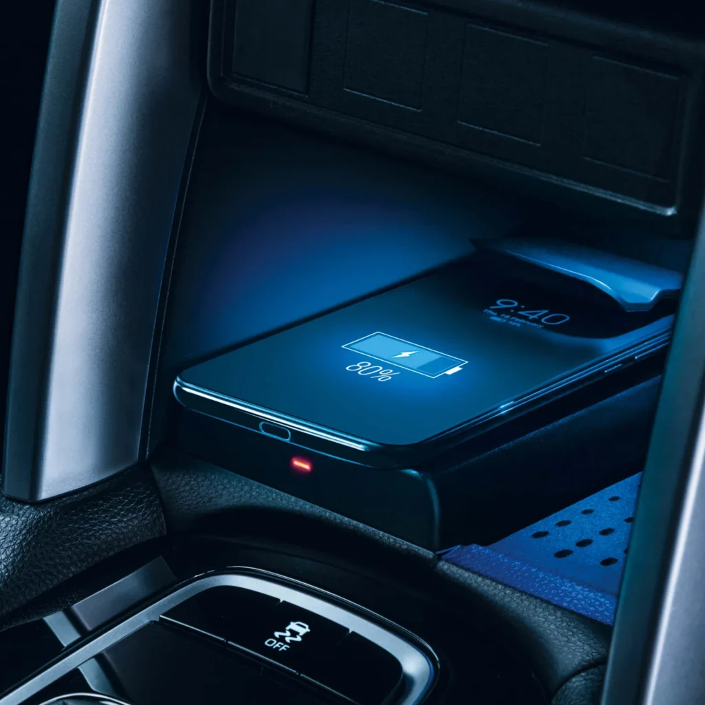 Toyota Corolla Cross Hybrid Electric wireless charging pad with smartphone displaying battery level and blue illumination