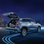 Toyota Corolla Cross Hybrid Electric with open tailgate showing cargo space against Kuala Lumpur city skyline