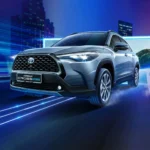 Toyota Corolla Cross Hybrid Electric positioned against modern cityscape with motion blur and light effects