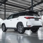 Toyota Fortuner SUV positioned in modern garage showing sleek profile and contemporary taillight design