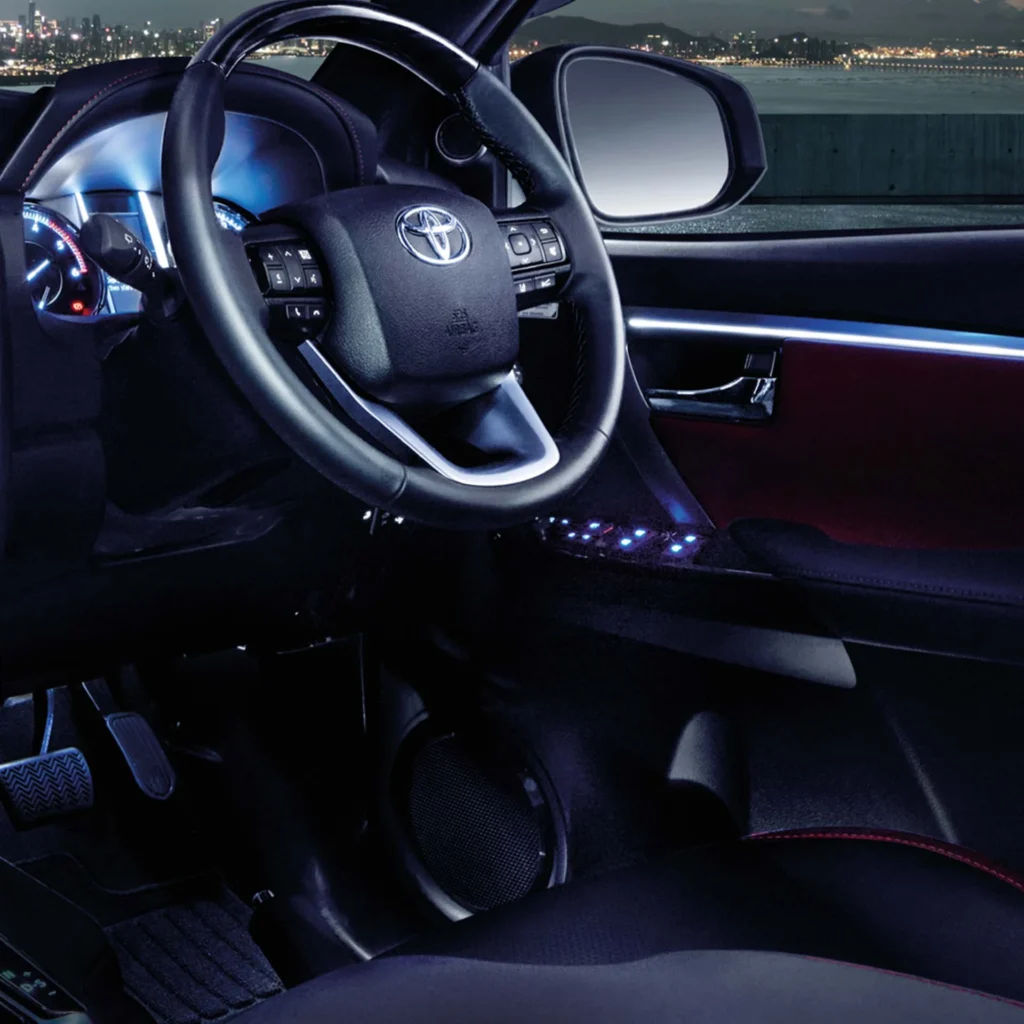 Toyota Fortuner interior dashboard view with infotainment system and illuminated city skyline through windshield
