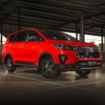 Red Toyota Innova parked in industrial setting showcasing bold exterior styling and premium wheel design