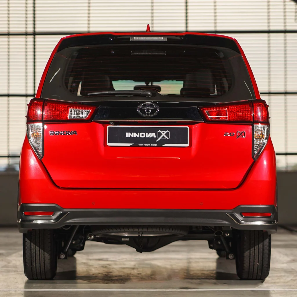 Rear view of red Toyota Innova showcasing tailgate design, brake lights, and modern proportions