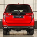Rear view of red Toyota Innova showcasing tailgate design, brake lights, and modern proportions