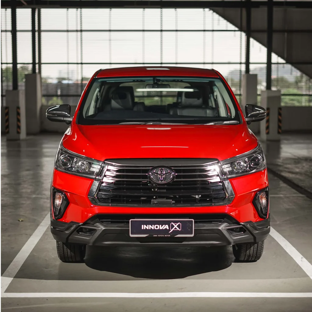 Front view of red Toyota Innova displaying bold grille design, LED headlights, and rugged bumper styling