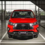 Front view of red Toyota Innova displaying bold grille design, LED headlights, and rugged bumper styling