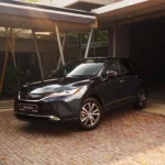 Toyota Harrier three-quarter front view in industrial warehouse setting with exposed steel beams and lighting