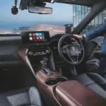 Toyota Harrier dashboard view showing driver operating touchscreen display with smartphone connectivity apps