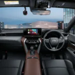 Toyota Harrier interior dashboard with touchscreen infotainment system and brown leather trim in urban setting