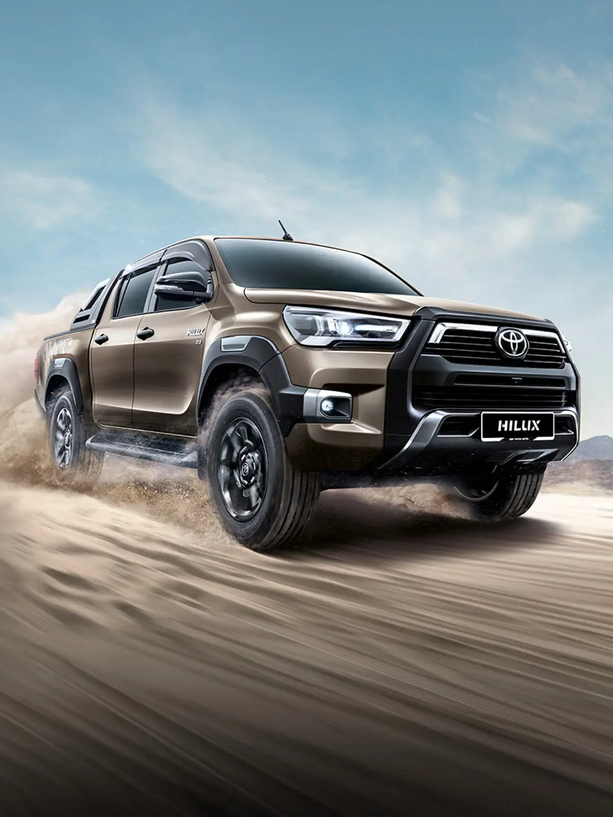 Toyota Hilux double cab showcasing off-road capability with alloy wheels on challenging rocky outcrop