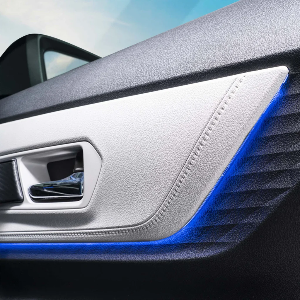 Close-up of Toyota Veloz car door interior showing blue trim lighting and silver handle with leather texture