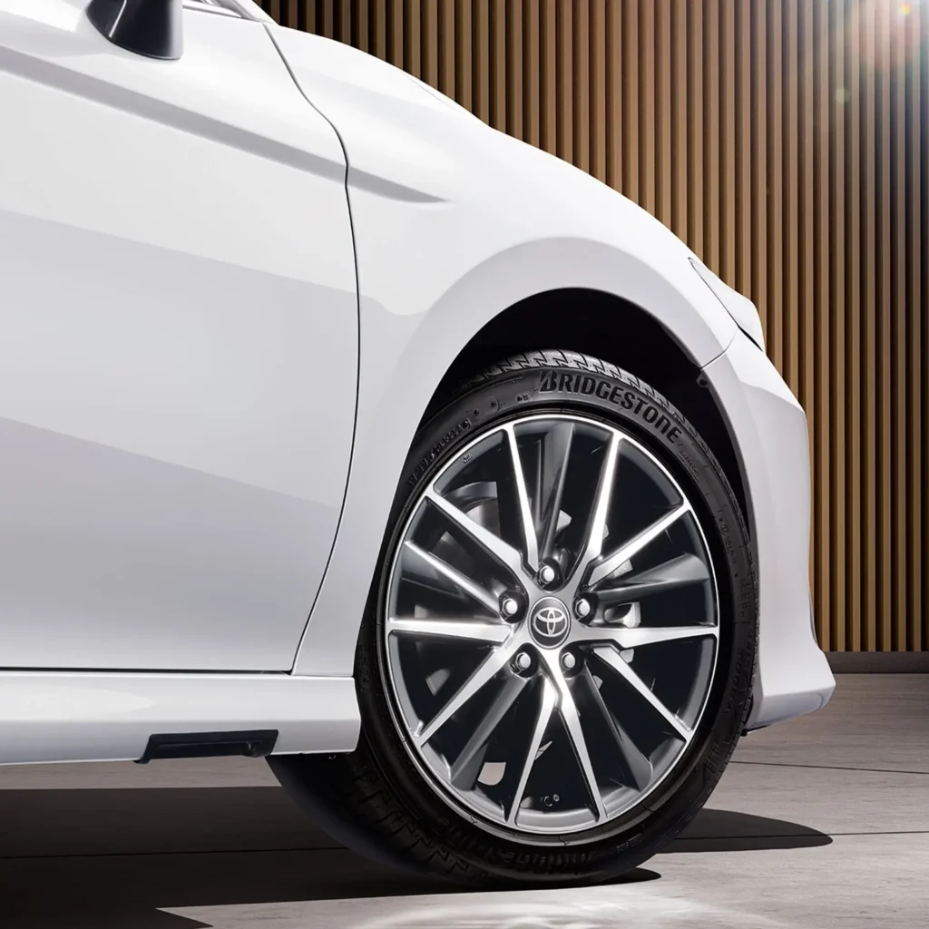 Close-up of white Toyota Camry alloy wheel with Bridgestone tire showing spoke design and brand logo