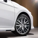 Close-up of white Toyota Camry alloy wheel with Bridgestone tire showing spoke design and brand logo